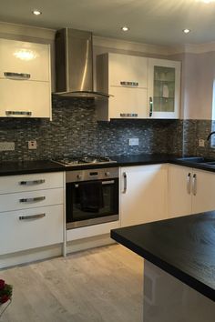 a kitchen with white cabinets and black counter tops