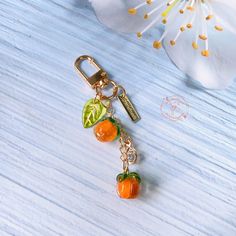 an orange keychain with three charms hanging from it