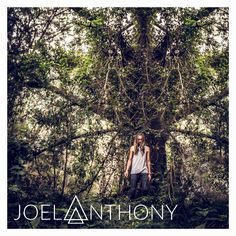 a man standing in front of a tree with the words joelanthony on it