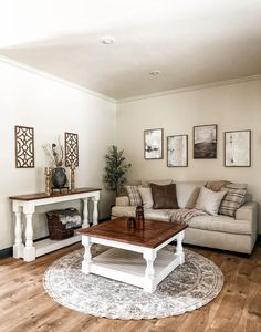 a living room filled with furniture and a coffee table in front of a white couch