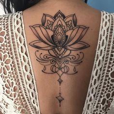 the back of a woman's neck with a lotus tattoo on it