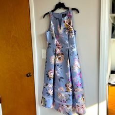 a dress hanging up on a wall in front of a door with an open drawer