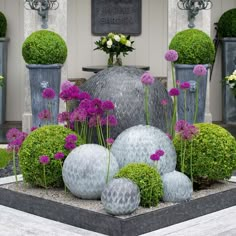 some very pretty vases with flowers and plants in them on the side of a building