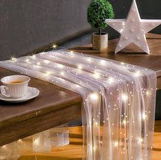 a table topped with a cup of coffee next to a white star on top of a wooden table