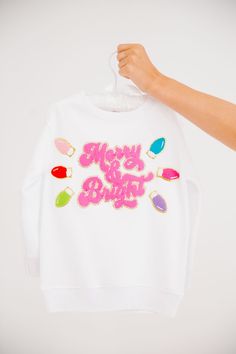 Get your little ones in the festive spirit with our MINI KIDS MERRY & BRIGHT WHITE PULLOVER. This white pullover features a playful pink Merry & Bright patch and festive christmas lights patches. Perfect for adding a touch of holiday cheer to their outfit! All orders are currently shipping within 14 business days. To receive item quicker, expedited shipping is available at checkout. **All Christmas orders must be placed with expedited shipping to guarantee delivery by Dec. 24 if placed after Dec Judith March, White Pullover, Festive Christmas, Merry And Bright, Holiday Cheer, Christmas Lights, Bright White, Pre Order, Festival