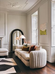 a living room filled with furniture and a fire place in the middle of it's wall