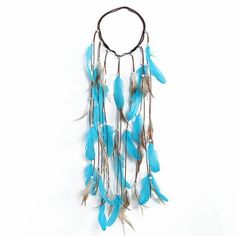 a necklace with blue feathers hanging from it's side on a white background,