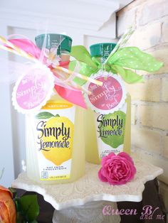 two bottles of simply lemonade on a shelf with flowers and paper streamers in the background