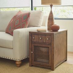 a living room with a couch, table and lamp on the floor next to it