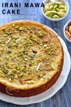 a cake on a plate with nuts and pistachios around it