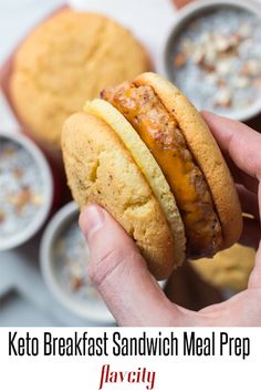 a person holding a sandwich in their hand with other dishes behind it and the words keto breakfast sandwich meal prepped