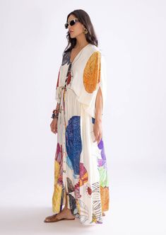 The shiloh kaftan features a vibrant tribal print in ivory and multi-colored hues. Crafted from luxurious habutai fabric, it includes a drawstring waistline that allows for a customizable fit, blending bold patterns with elegant, flowing design. Bohemian Silk Dress With Ikat Print, Multicolor Ikat Print Kaftan Tunic, Multicolor Long Sleeve Hippie Kaftan, Multicolor V-neck Kaftan With Batik Print, Bohemian Multicolor Print V-neck Kaftan, Hippie Multicolor Kaftan With Kimono Sleeves, Bohemian Batik Print Patterned Kaftan, Bohemian Kimono With Abstract Print For Vacation, Bohemian Silk Multicolor Print Dress