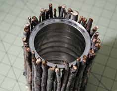 there is a metal cup that has many sticks sticking out of it's sides