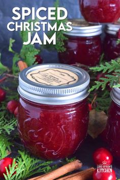 three jars filled with cranberry sauce surrounded by christmas greenery and cinnamon sticks