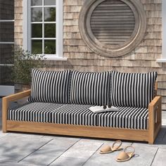 a wooden couch sitting on top of a patio