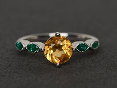 Welcome to my shop, you can find many beautiful gemstone jewelry here, and you also can ask for customized service. Main Stone: yellow citrine, round cut, measures 7X7mm, weight 1.26 caratsAccent Stones: lab created emeraldMetal: 925 sterling silver plated with rhodium. I also can provide metal options such as 14k solid yellow/white/rose goldSetting: four claw basket settingIf you want to know more rings please go to my shop home: https://www.etsy.com/shop/XCjewelryStudio?ref=hdr_shop_menuIt's q Yellow Sapphire Ring With Round Cut Gemstone, Elegant Yellow Topaz Ring With Round Cut, Elegant Yellow Topaz Ring Round Cut, Elegant Yellow Round Cut Topaz Ring, Yellow Round Topaz Ring With Prong Setting, Yellow Topaz Promise Ring, Round Cut, Yellow Topaz Round Ring, Yellow Topaz Ring With Round Cut Center Stone, Topaz Citrine Ring With Center Stone