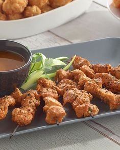 chicken skewers and dipping sauce on a plate