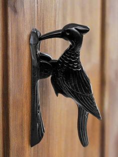 a black bird is on the handle of a door