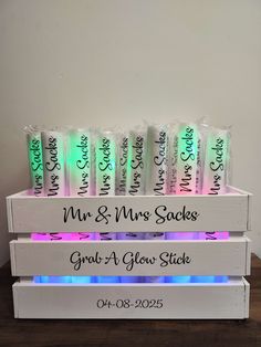 personalized wedding candy bars with glow in the dark labels on white wooden crates for guests to use