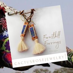 "Foresthill \"loom look\" earrings Genuine leather wire wrapped with metal bugle beads and Japanese cylinder beads embellished with winter white cotton tassels. Gift box included for gift presentation or let's be honest... Wrap them up and give them to yourself!" Tassels Handmade, Gift Presentation, Blue Iris, Bead Weaving Patterns, Bracelet Kits, Bugle Beads, Earring Ideas, Jewelry To Make, Weaving Patterns