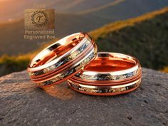 two wedding bands sitting on top of a rock