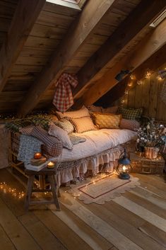 an attic bedroom with wooden flooring and lights on the ceiling, bed is made out of wood planks