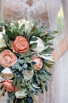 a bridal bouquet with peach and white flowers on the bride's wedding day