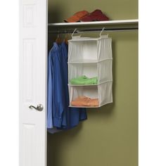 an open closet door with clothes hanging on the rack and shoes in the bins