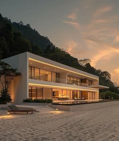 a large white house sitting on top of a sandy beach next to the ocean at sunset