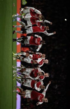 the soccer players are lined up in a row on the sidelines for a team photo