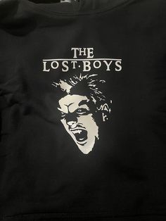 the lost boys t - shirt is black and white with an image of a man's face on it