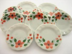 six orange and green flowers on white plates