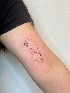 a woman's arm with a small outline of a bird on it and a flower in the middle