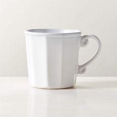 a white coffee cup sitting on top of a table