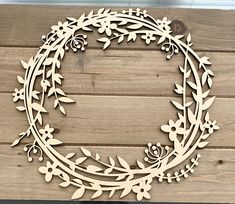 a wooden wreath with leaves and flowers cut out