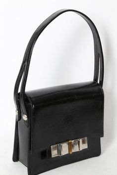 Vintage Black Snake Embossed Leather Bow Handbag Purse Bag is Pre-owned, Good Condition Scratches on hardware. Light wear on sides Snap closure Black color Leather body Silver tone hardware Interior features: one zipper & one slide pockets Brand: Unbranded Material: Leather Measurements in Inches: * Length across: 7.75 * Height: 7 * Bottom wide: 2.5 * Leather handles drop: 6 Formal Handheld Shoulder Bag With Branded Hardware, Rectangular Leather Evening Bag With Metal Hardware, Vintage Rectangular Bag With Branded Hardware, Square Evening Shoulder Bag With Branded Hardware, Evening Rectangular Satchel With Branded Hardware, Evening Square Shoulder Bag With Branded Hardware, Formal Square Box Bag With Branded Hardware, Vintage Shoulder Bag With Branded Hardware For Evening, Vintage Evening Shoulder Bag With Branded Hardware