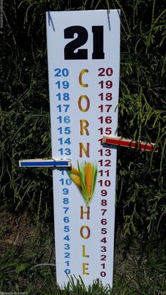 a white sign with numbers on it in the grass