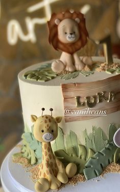 a birthday cake with a lion and giraffe on top