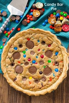 a chocolate chip cookie pie with m & m candy on it's crust, ready to be eaten