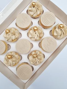 twelve cupcakes in a box with gold decorations