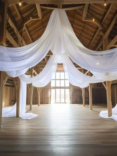 an open room with white drapes and wood floors