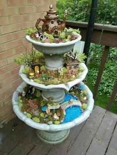 three tiered planter filled with miniature garden items