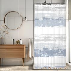 a white and blue shower curtain in a bathroom with a wooden cabinet next to it