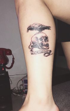 a person with a skull and an eagle tattoo on their leg