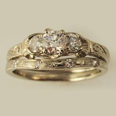 two gold wedding rings with diamonds on each one and an engagement ring in the middle