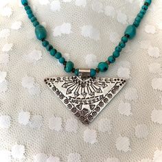 This 18 inch turquoise boho chic tribal necklace features turquoise and smokey topaz gemstones with a hand stamped Hill Tribe silver pendant triangular in shape. This striking pendant, intricately hand made and stamped by the Hill Tribe women artisans of Thailand to support their families, measures over 2 inches at its widest point and hangs gracefully from the necklace. Hill Tribe silver is 97.5 to 99 % pure silver. The turquoise stones are rich in color with a slight black matrix, varying in s Artisan Adjustable Turquoise Pendant Necklace, Adjustable One-of-a-kind Turquoise Necklace For Festivals, Bohemian Nickel-free Pendant Necklace, Bohemian Turquoise Jewelry With Natural Stones, Southwestern Turquoise Etched Jewelry, Spiritual Turquoise Necklace For Festivals, Southwestern Etched Turquoise Jewelry, Southwestern Style Etched Turquoise Jewelry, Nickel Free Bohemian Necklace For Festivals