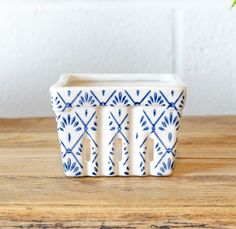 a blue and white planter sitting on top of a wooden table