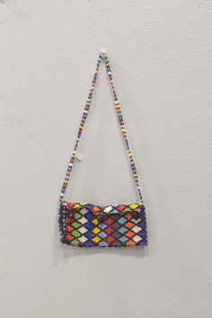 This is a wonderful Vintage Zulu Colorful Beaded Purse from South Africa. For many Zulu beaded jewelry, garments, and other accessories became important markers of identity. Bead work was a visual marker of social position, marital status, ethnic affiliation and location of the family's homeland. Stylistic variations of bead work such as pattern, color and color sequence indicate area or group affiliation. Colors and patterns take on more personally expressive meanings. This is a lovely old beaded Zulu Purse would be a great addition to your collection or home. Late 20th- Century Shows age, and Natural Wear 26 Inches Long Handle to Bottom Purse 4 Inches Tall When Opened 3 Inches Tall Closed 1 Inch Wide 6 Inches Long Strap 21 Inches Long AT BACARA WE STAND BEHIND ALL OF OUR MERCHANDISE. FUL Multicolor Rectangular Beaded Necklace For Festivals, Multicolor Beads With Bead Caps For Crafting, Multicolor Rectangular Beaded Necklaces, Large Rectangular Multicolor Beads, Marital Status, Married Woman, Zulu, Womens Purses, Bead Work