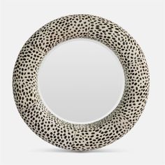 a white and black leopard print circle mirror on a gray background with the reflection of it's spots