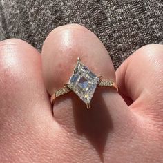 a person's hand with a diamond ring on it